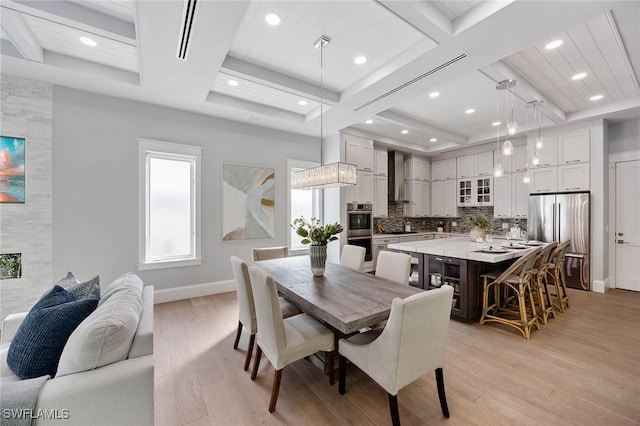 dining area with light wood finished floors, baseboards, and coffered ceiling