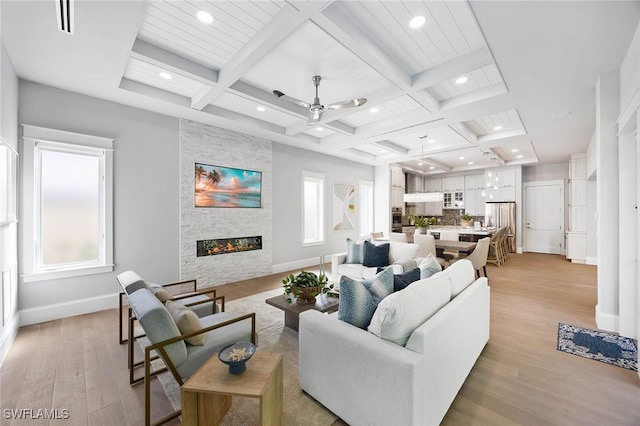 living room with a healthy amount of sunlight, a fireplace, and coffered ceiling