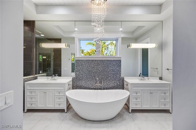 bathroom with marble finish floor, a soaking tub, two vanities, and a shower stall