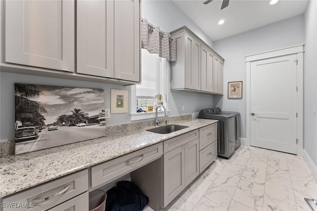 clothes washing area with cabinet space, marble finish floor, washing machine and dryer, a sink, and recessed lighting