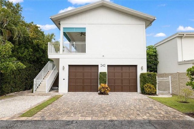 view of front facade with stairs, decorative driveway, a balcony, and a garage