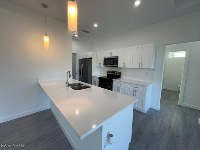 kitchen featuring appliances with stainless steel finishes, hanging light fixtures, white cabinetry, and sink