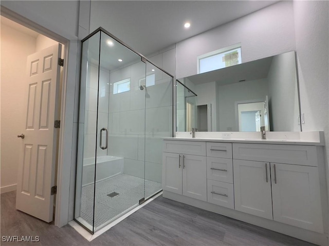 bathroom with vanity, walk in shower, and hardwood / wood-style flooring