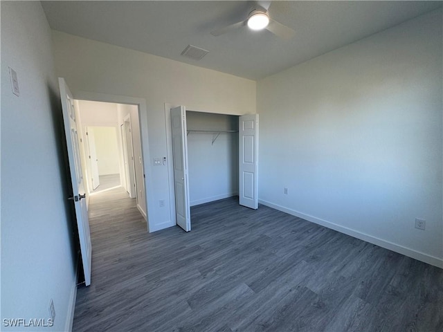 unfurnished bedroom with dark hardwood / wood-style flooring, a closet, and ceiling fan