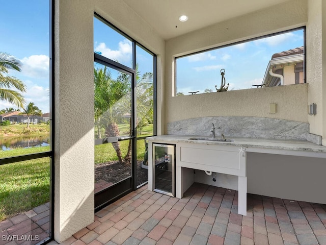 interior space with a water view, sink, and wine cooler