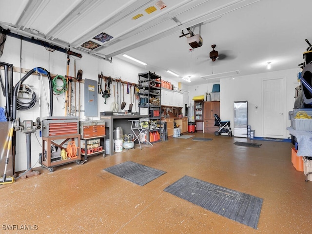 garage featuring a workshop area, electric panel, and a garage door opener