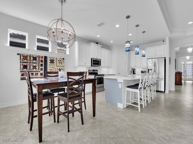 tiled dining space featuring a raised ceiling, sink, and a chandelier