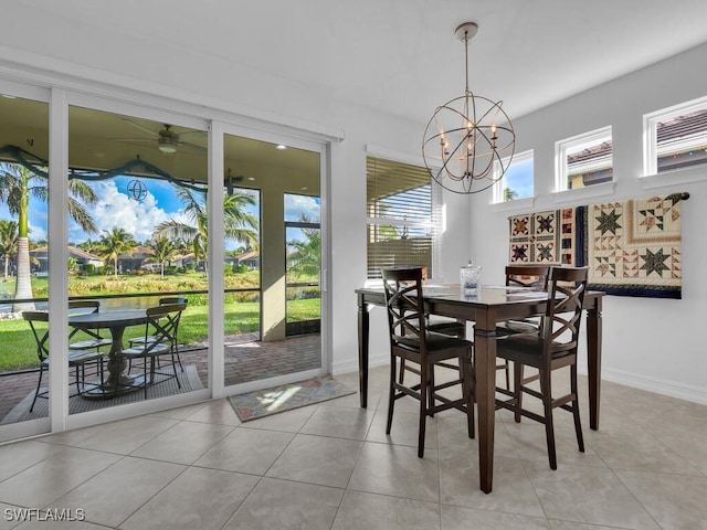 tiled dining area featuring ceiling fan with notable chandelier