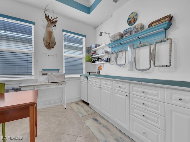 kitchen featuring light tile patterned floors and white cabinetry