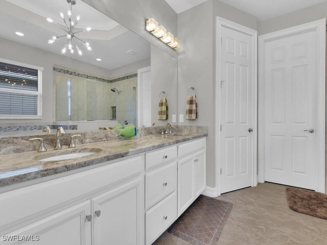 bathroom featuring vanity, an enclosed shower, and a chandelier