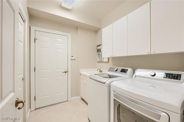 laundry room featuring washer and clothes dryer, cabinets, and sink