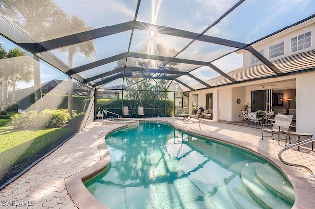 view of pool with glass enclosure and a patio area