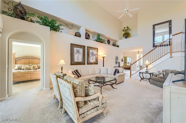 living room with ceiling fan, light carpet, and high vaulted ceiling