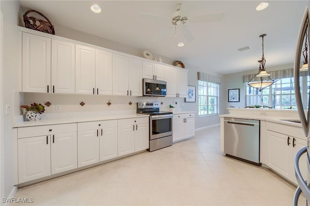 kitchen featuring white cabinets, appliances with stainless steel finishes, decorative light fixtures, and ceiling fan