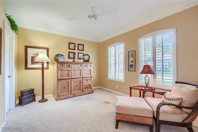 sitting room with a wealth of natural light, light carpet, ceiling fan, and ornamental molding