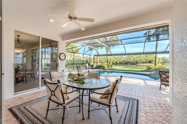 sunroom / solarium with ceiling fan, a healthy amount of sunlight, and a swimming pool