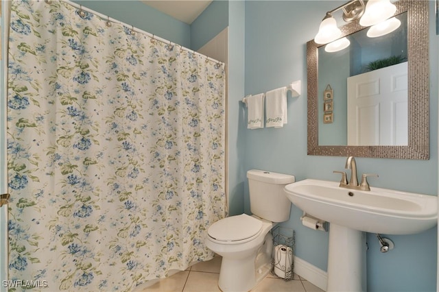 bathroom featuring tile patterned floors, toilet, and curtained shower