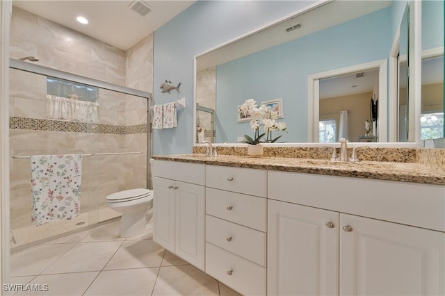 bathroom with tile patterned floors, vanity, toilet, and an enclosed shower