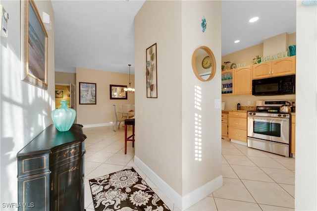 kitchen with an inviting chandelier, decorative light fixtures, light tile patterned floors, light brown cabinets, and stainless steel range