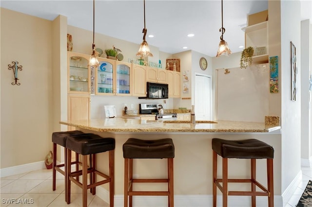 kitchen featuring stainless steel stove, light stone countertops, a kitchen bar, decorative light fixtures, and kitchen peninsula