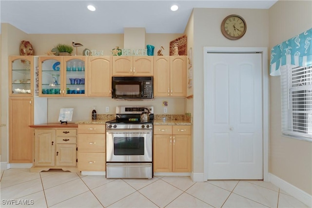 kitchen featuring light stone counters, stainless steel gas range, light tile patterned floors, and light brown cabinets