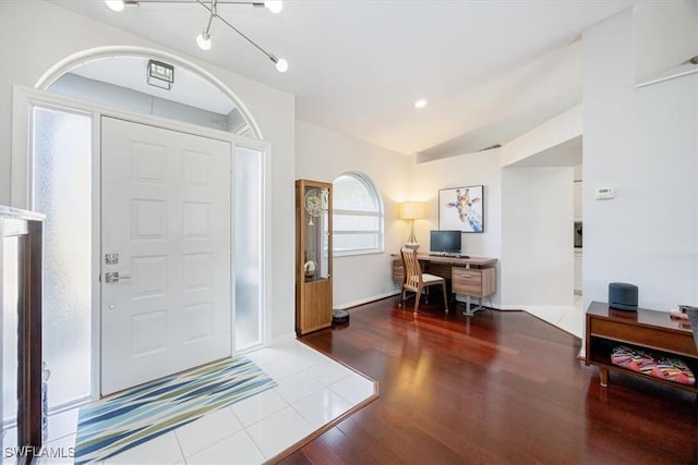 foyer featuring hardwood / wood-style floors and vaulted ceiling