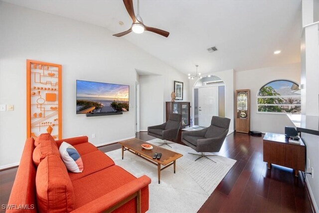 living room featuring ceiling fan with notable chandelier, dark wood-type flooring, and high vaulted ceiling