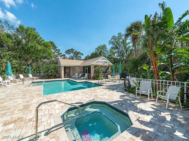 view of swimming pool with a community hot tub and a patio area