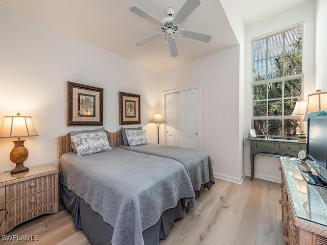 bedroom with light wood-type flooring, a closet, and ceiling fan