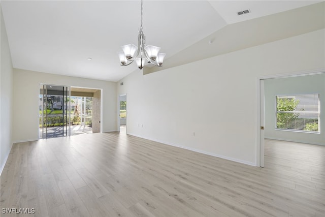 empty room with light wood-type flooring, lofted ceiling, and an inviting chandelier