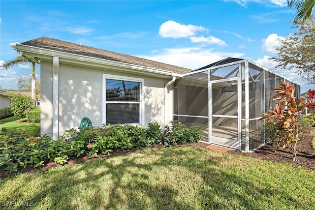 back of property featuring a lanai and a yard