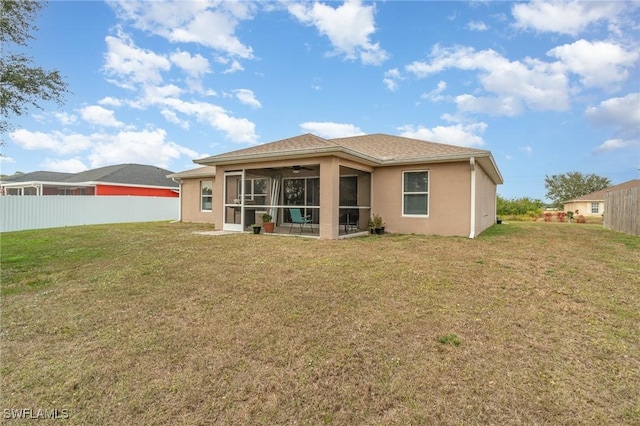 back of property featuring a lawn and a sunroom