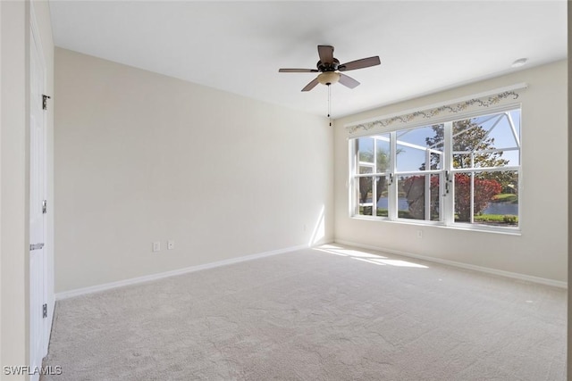 spare room featuring light carpet and ceiling fan