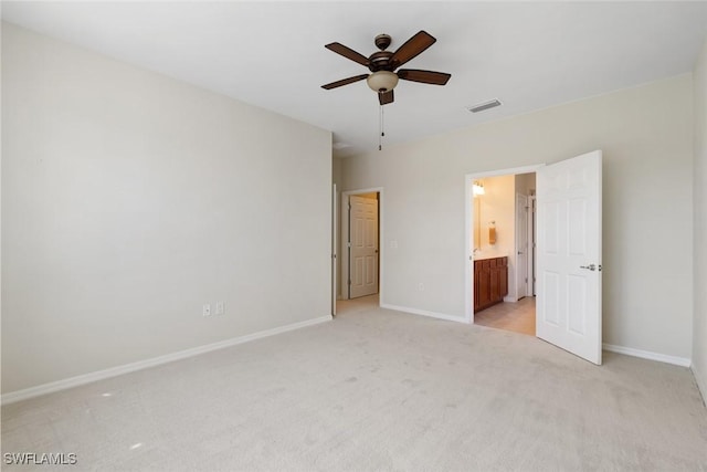 unfurnished bedroom featuring ensuite bathroom, ceiling fan, and light carpet