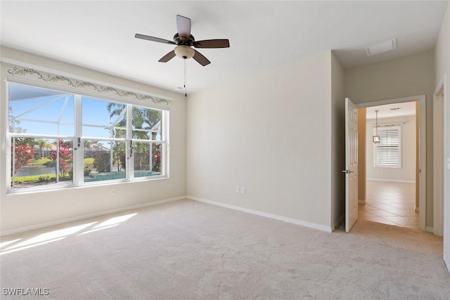 spare room featuring a wealth of natural light, ceiling fan, and light colored carpet