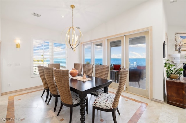 dining area with a notable chandelier and a water view