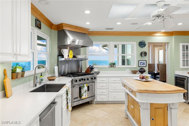 kitchen featuring sink, wine cooler, extractor fan, a kitchen island, and appliances with stainless steel finishes