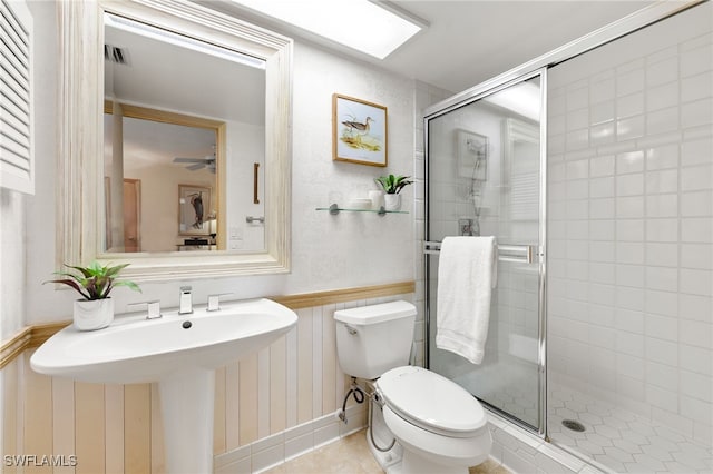 bathroom featuring ceiling fan, sink, walk in shower, tile patterned floors, and toilet