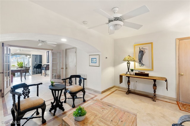 sitting room with ceiling fan and french doors