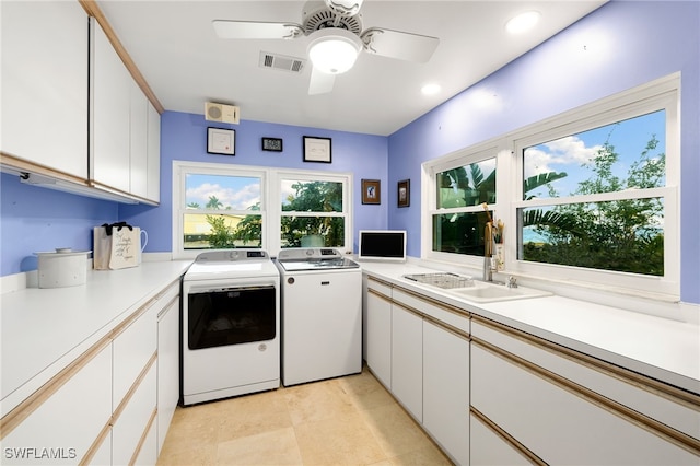 laundry area featuring ceiling fan, cabinets, independent washer and dryer, and sink