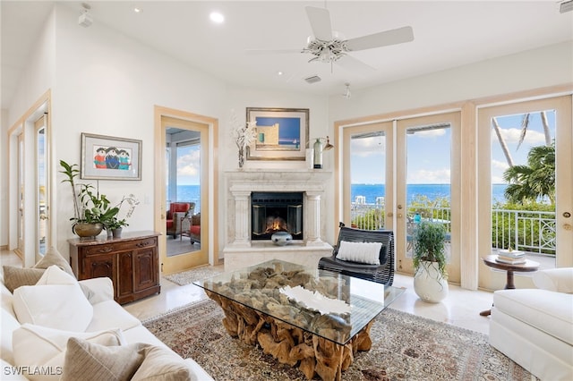 living room featuring ceiling fan, a water view, and a wealth of natural light