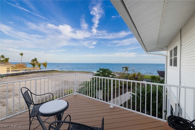 balcony with a water view and a view of the beach