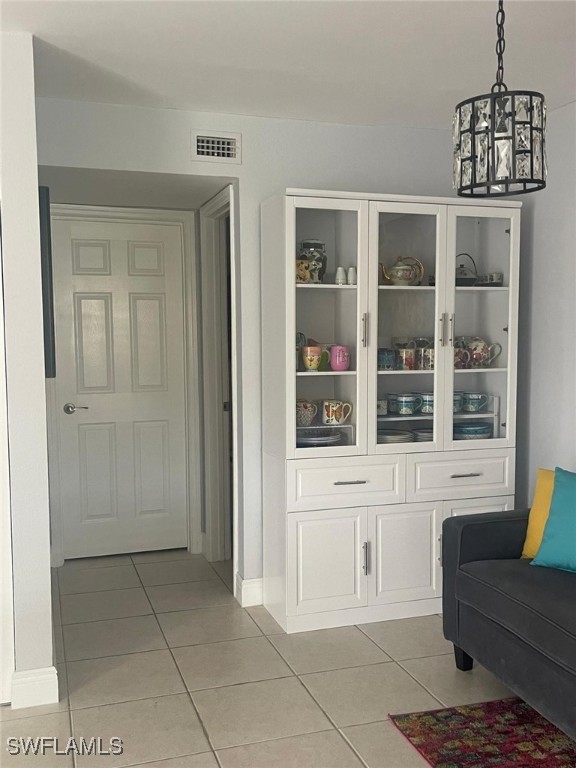 interior space with a notable chandelier and light tile patterned flooring