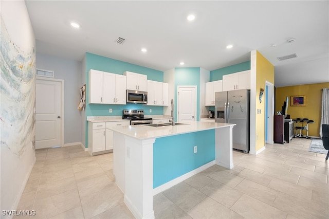 kitchen featuring white cabinetry, a center island with sink, sink, and appliances with stainless steel finishes