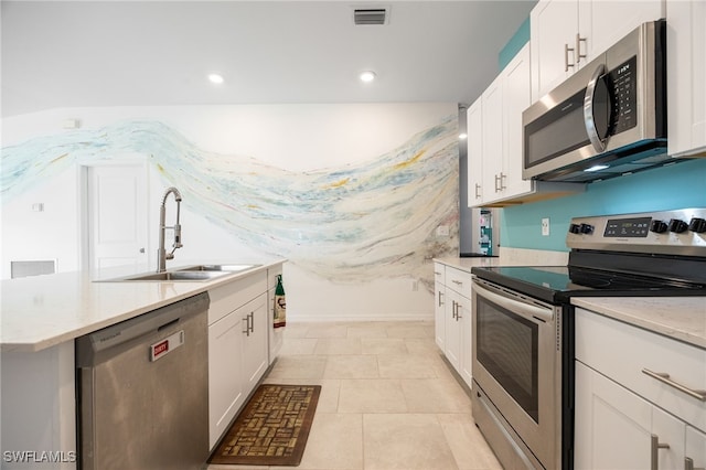 kitchen with light tile patterned floors, stainless steel appliances, white cabinetry, and sink