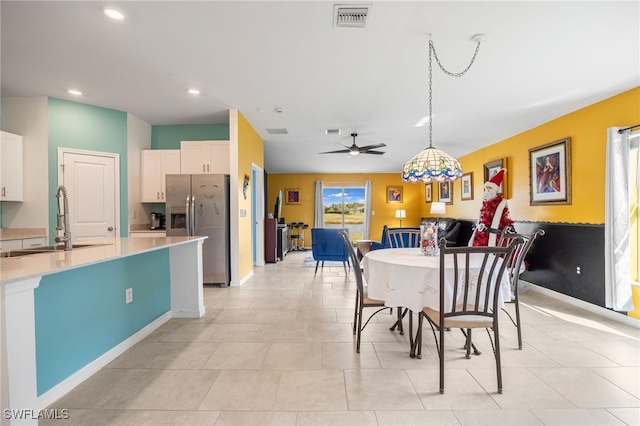 dining room with ceiling fan and sink