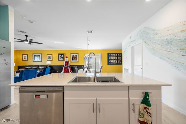 kitchen with light stone countertops, white cabinetry, stainless steel dishwasher, an island with sink, and ceiling fan with notable chandelier