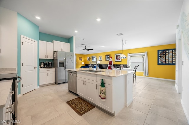 kitchen featuring stainless steel appliances, white cabinetry, hanging light fixtures, and a center island with sink