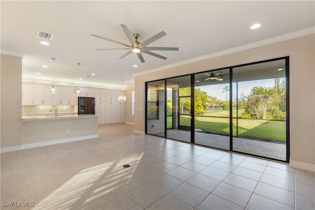 empty room with light tile patterned floors, ceiling fan, ornamental molding, and sink