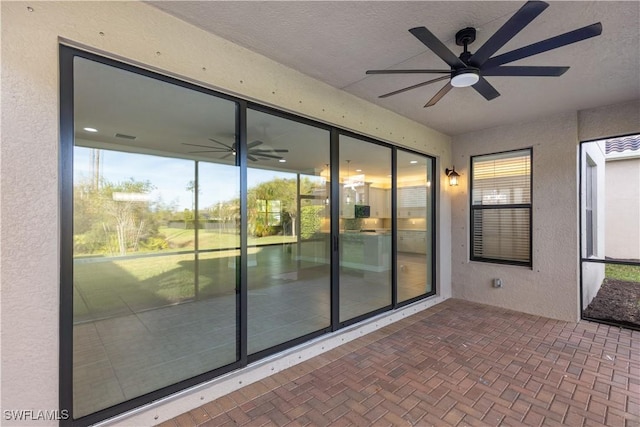 unfurnished sunroom with ceiling fan and a wealth of natural light